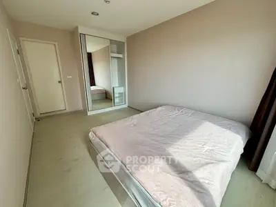 Spacious bedroom with large window and mirrored closet in modern apartment