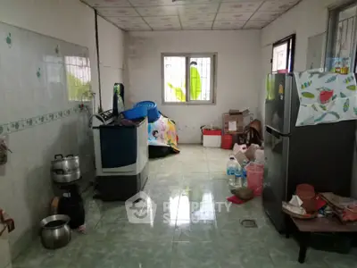 Spacious kitchen with tiled floor and essential appliances, ideal for family cooking.