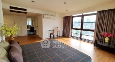 Spacious bedroom with city view and elegant decor in modern apartment.