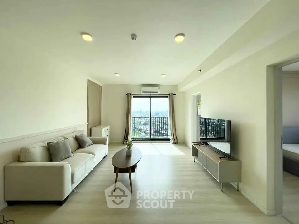 Spacious living room with modern decor and large window offering stunning city view.