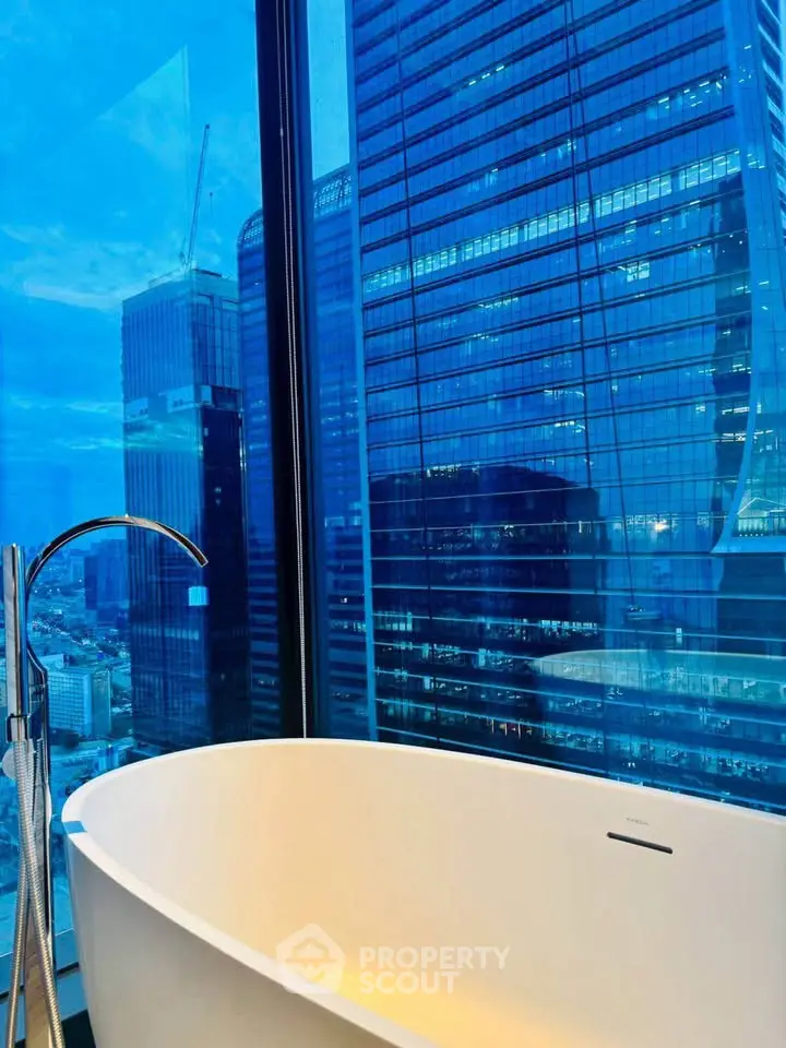 Luxurious bathroom with a stunning city view from a high-rise building window.