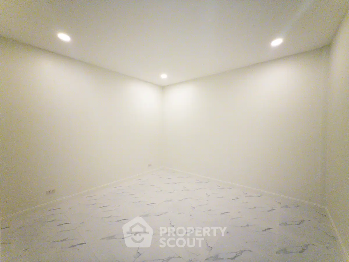 Spacious empty room with modern lighting and marble flooring