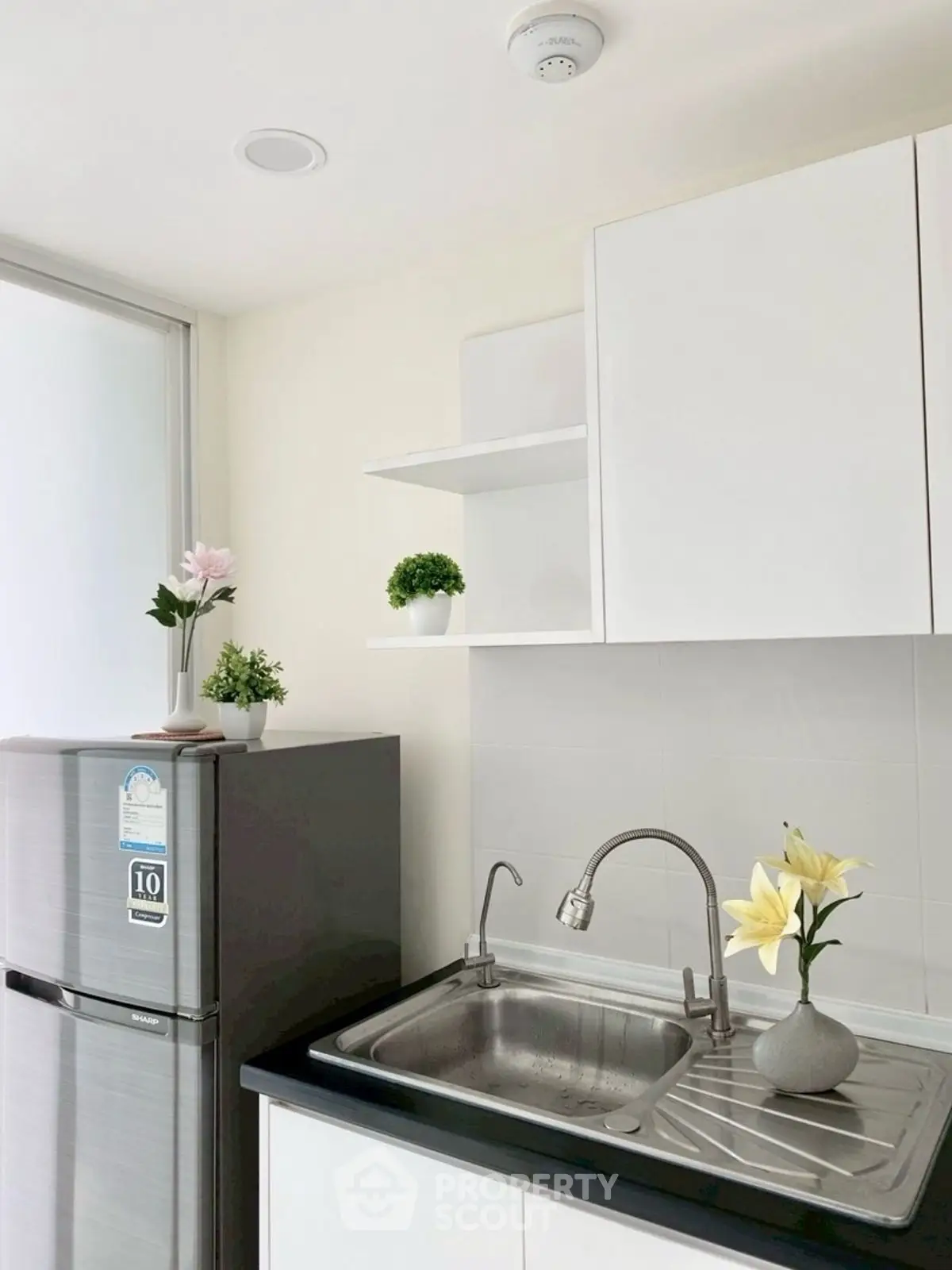 Modern kitchen with sleek white cabinets and stainless steel fridge