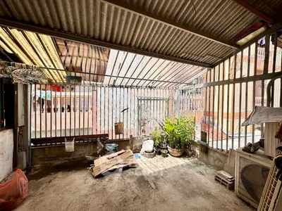 Spacious urban balcony with corrugated roof and potted plants
