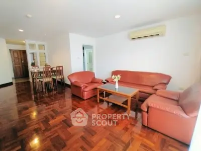 Spacious living room with elegant wooden flooring and comfortable leather seating