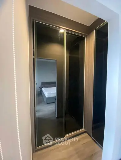 Modern walk-in closet with sleek mirrored doors and stylish interior design.