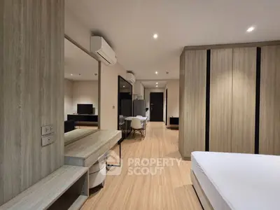 Spacious modern bedroom with wooden flooring and sleek furniture design