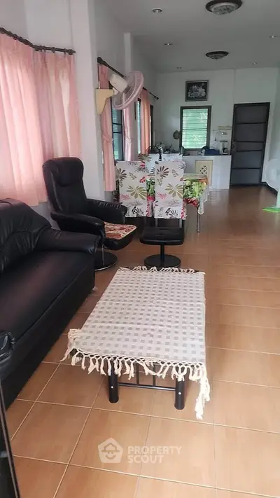 Spacious living room with cozy seating and natural light, perfect for relaxation and entertaining.