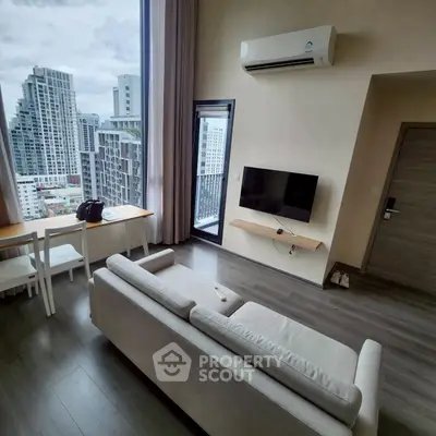 Modern living room with city view, featuring sleek furniture and large windows.