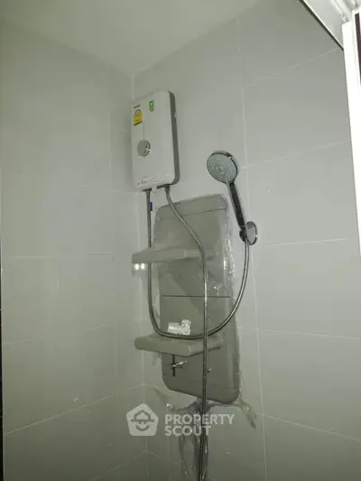 Modern bathroom with sleek shower unit and water heater installation.