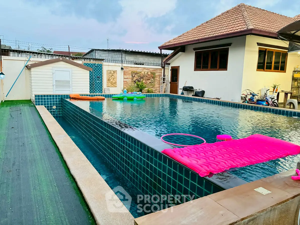 Luxurious private pool with modern tiles and cozy loungers in a serene backyard setting.