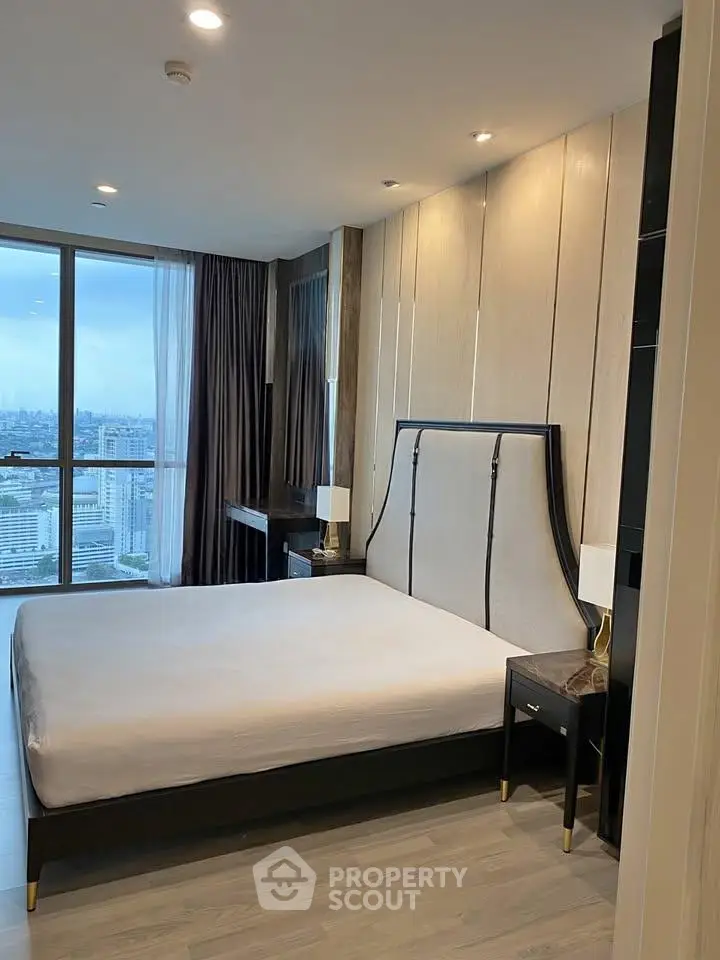 Luxurious bedroom with city view, modern decor, and elegant furnishings in high-rise apartment.