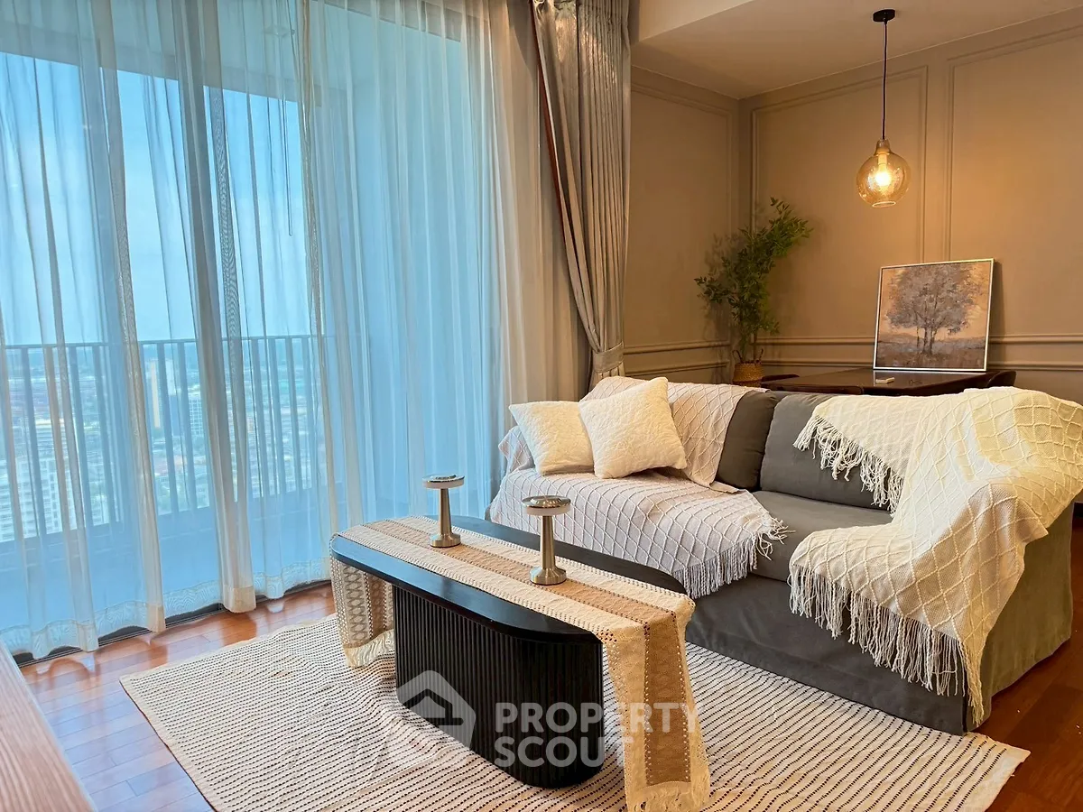 Chic living room with cozy sofa, elegant decor, and city view balcony.