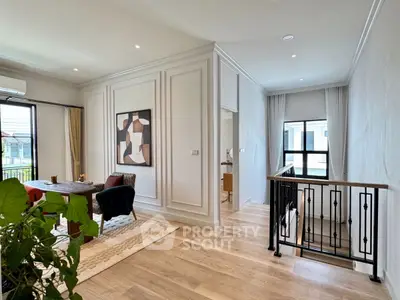 Elegant living area with modern decor and natural light, featuring stylish artwork and wooden flooring.