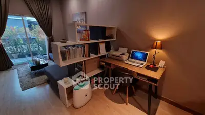 Modern living room with stylish study area and balcony access