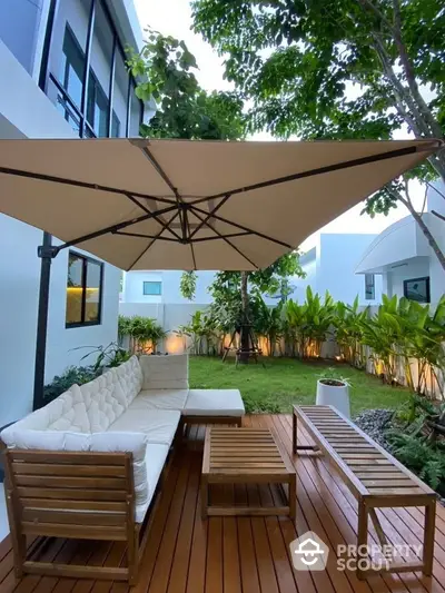 Modern garden patio with stylish wooden furniture and large umbrella