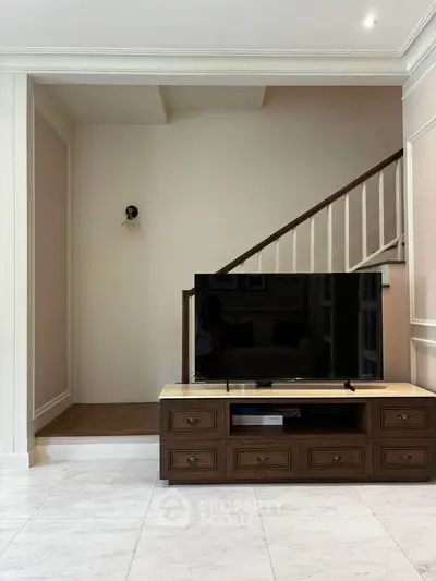 Elegant living room with modern TV setup and stylish wooden furniture