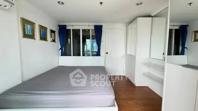 Modern bedroom with large bed, white decor, and blue curtains in a stylish apartment.