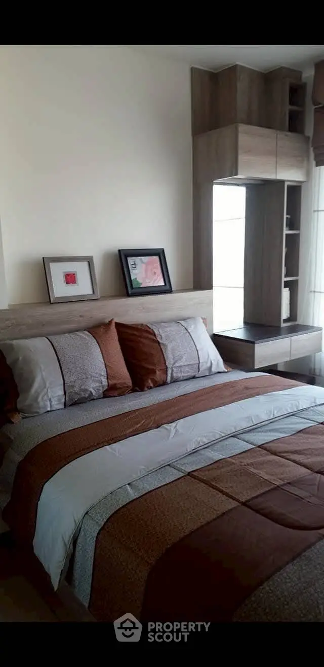 Cozy bedroom with modern decor and stylish bedding in a well-lit apartment.