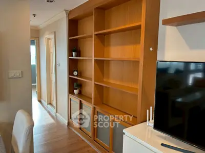 Spacious living room with elegant wooden shelving and modern TV setup