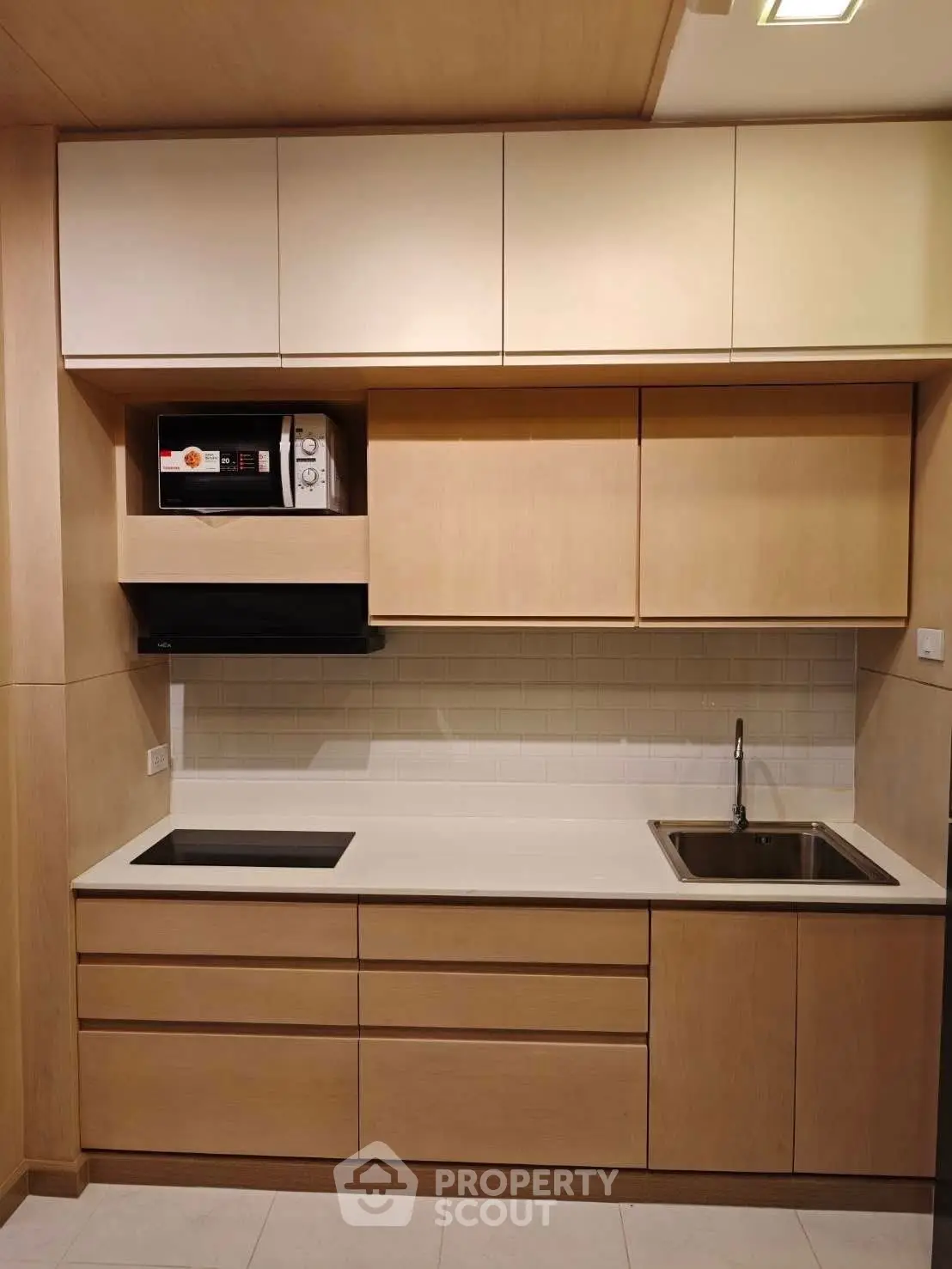 Modern kitchen with sleek cabinetry and built-in microwave, perfect for contemporary living.