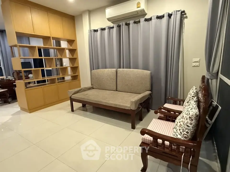 Spacious living room with elegant wooden furniture and modern shelving unit.