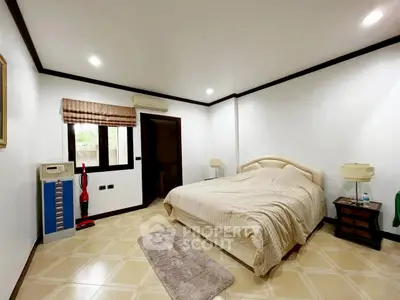 Spacious bedroom with elegant decor and ample natural light.