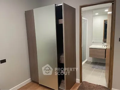 Modern interior with sleek wardrobe and bathroom view, showcasing contemporary design and functionality.