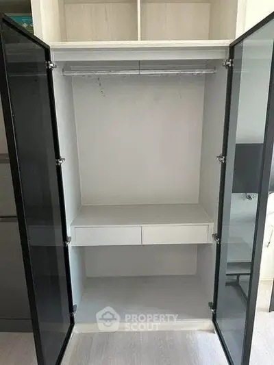 Spacious modern wardrobe with glass doors in a stylish interior setting.