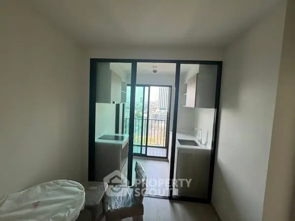 Compact kitchen with balcony view in modern apartment