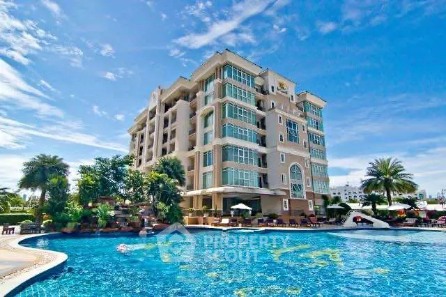 Luxurious apartment building with stunning pool and lush landscaping under a clear blue sky.