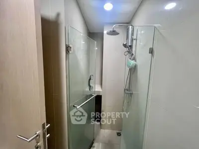 Modern bathroom with glass shower enclosure and sleek fixtures