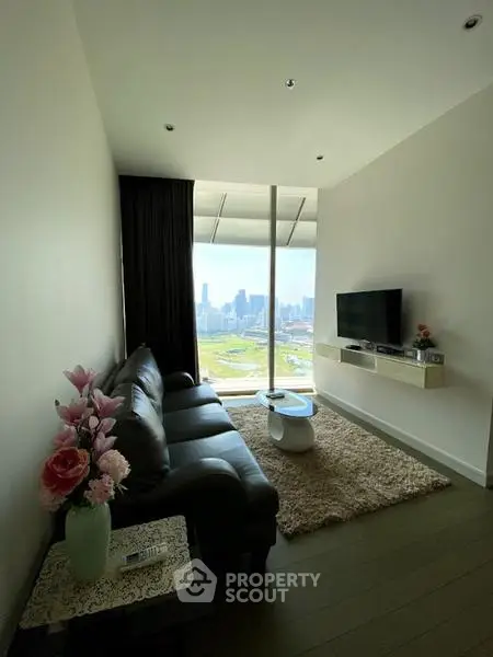 Modern living room with stunning city view, sleek furniture, and cozy decor.