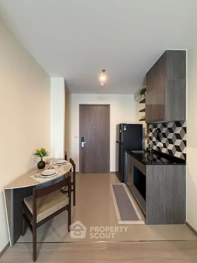Modern kitchen with sleek cabinetry and dining area in a stylish apartment