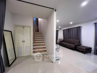 Spacious living room with elegant staircase and modern decor