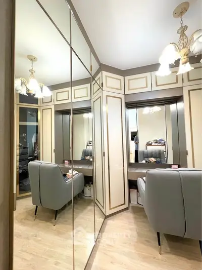 Luxurious walk-in closet with elegant seating and mirrored wardrobes