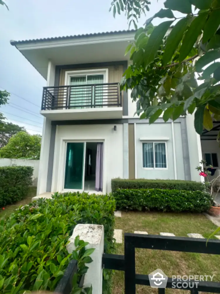 Charming two-story house with lush garden and balcony in a serene neighborhood.