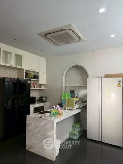 Modern kitchen with marble island and built-in appliances