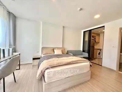 Modern studio apartment with cozy bed, stylish sofa, and in-unit washing machine.