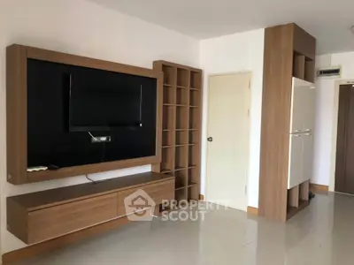 Modern living room with sleek wooden TV unit and storage shelves, perfect for stylish urban living.