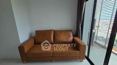 Modern living room with leather sofa and balcony view