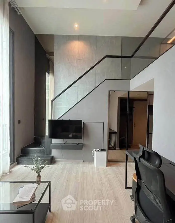 Modern living room with high ceiling and stylish staircase in a contemporary apartment.