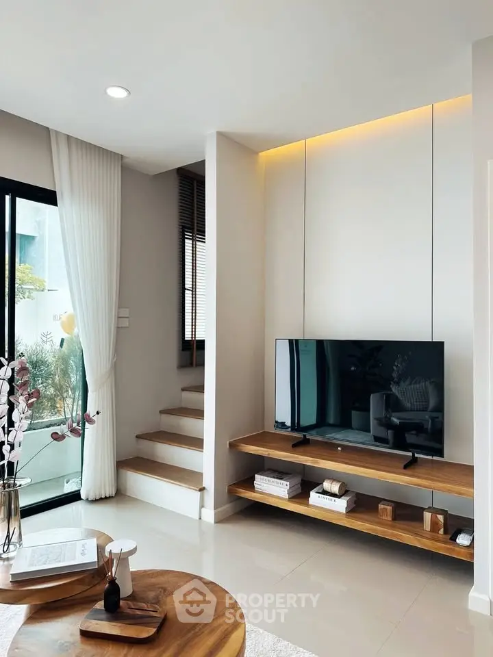 Modern living room with sleek TV setup and natural light