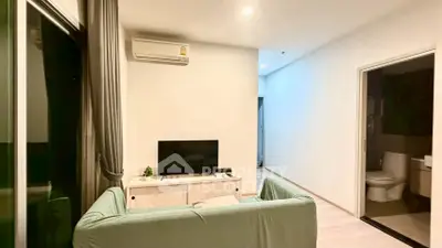 Modern living room with air conditioning and sleek design, featuring a cozy sofa and entertainment unit.
