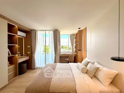 Spacious and bright bedroom with modern decor and large window offering scenic views.