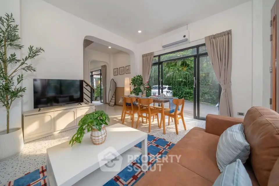 Spacious living room with modern decor and large windows offering garden views.