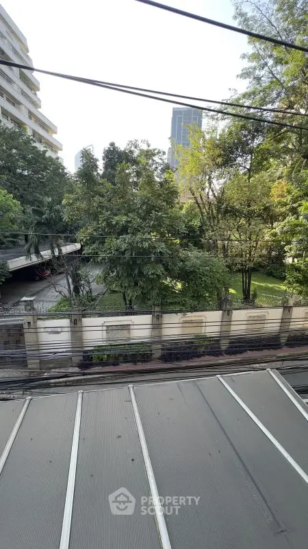 Serene urban view with lush greenery and modern buildings, perfect for city living.