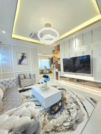 Luxurious living room with elegant decor, plush seating, and modern chandelier in a stylish home.
