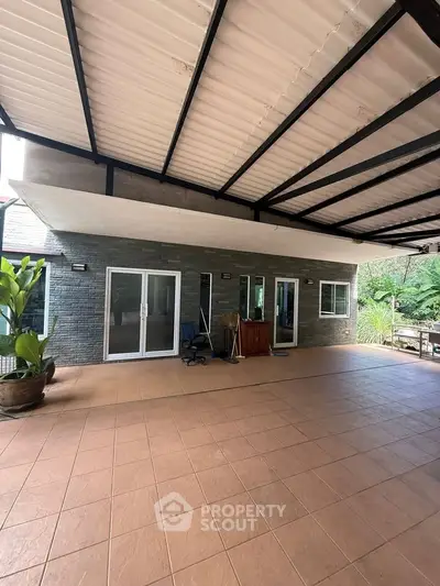 Spacious covered patio with modern design and lush greenery