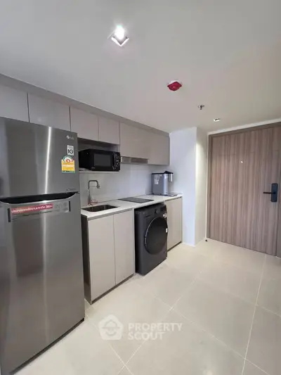 Modern kitchen with sleek appliances and minimalist design in a contemporary apartment.